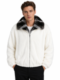 A man wearing a white faux fur zip-up jacket with a black and gray patterned faux fur collar, paired with black pants, against a plain white background.